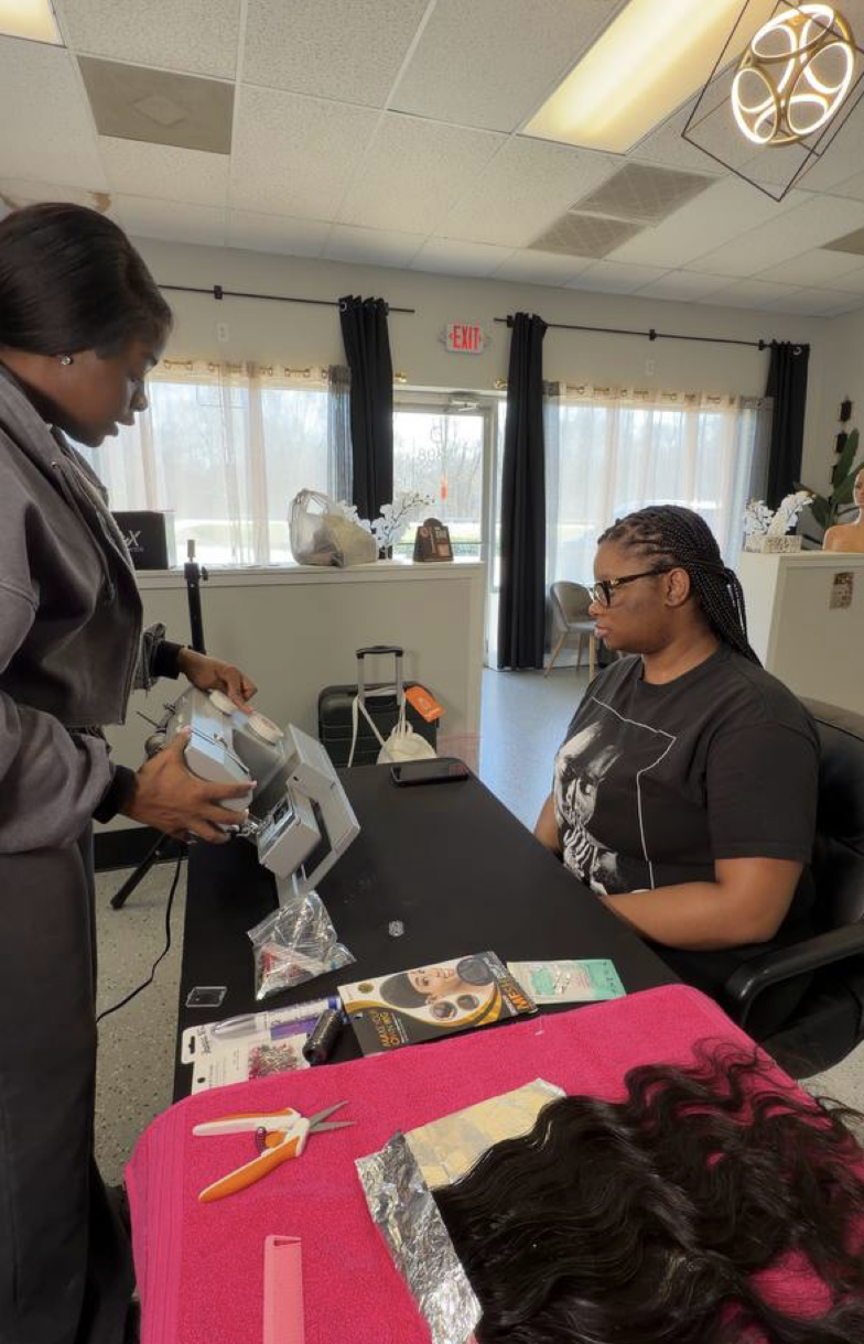 Infiniti demonstrating sewing machine setup to a seated student